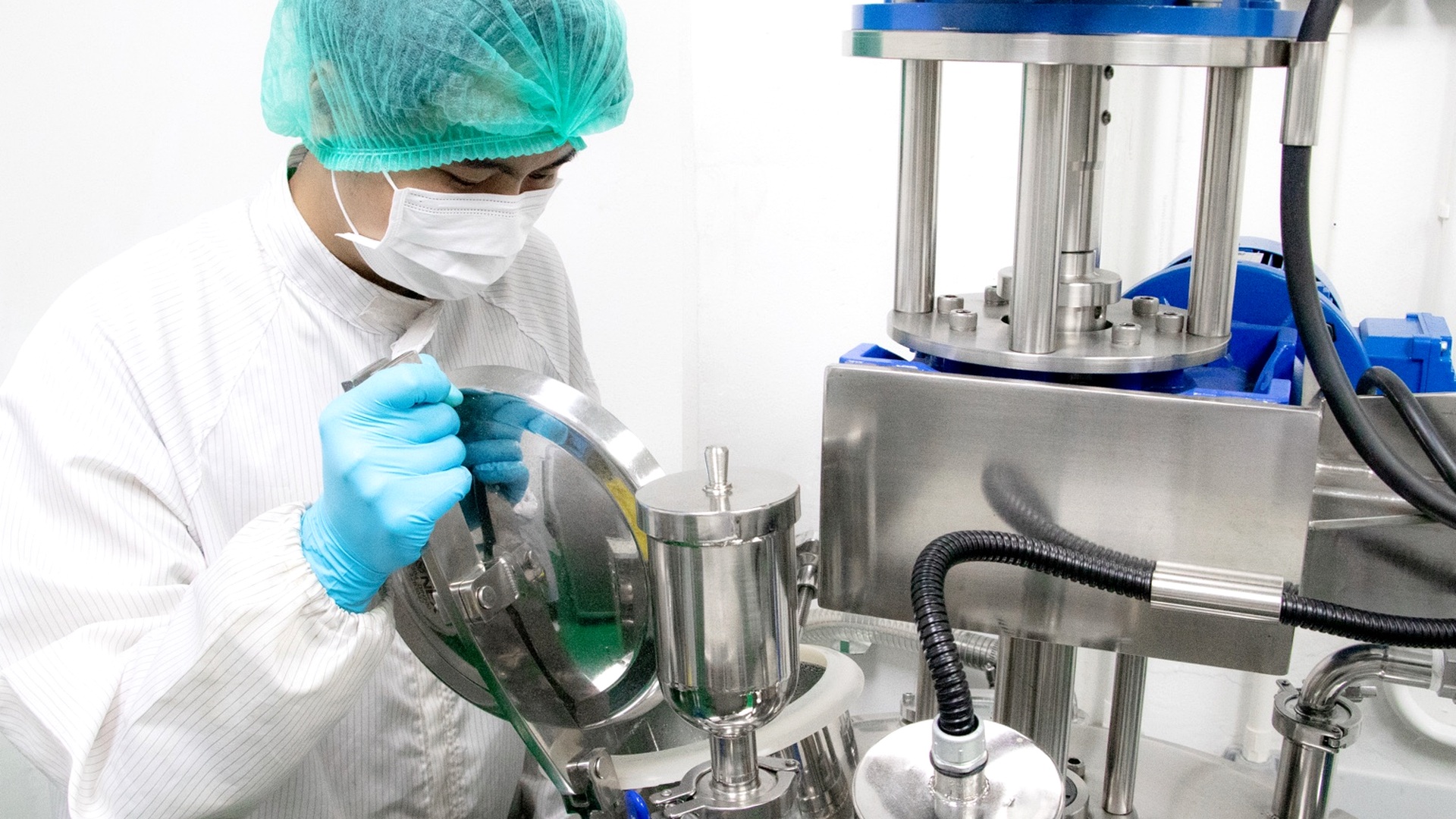 A Marine Biotech operator working at stainless-steel production equipment